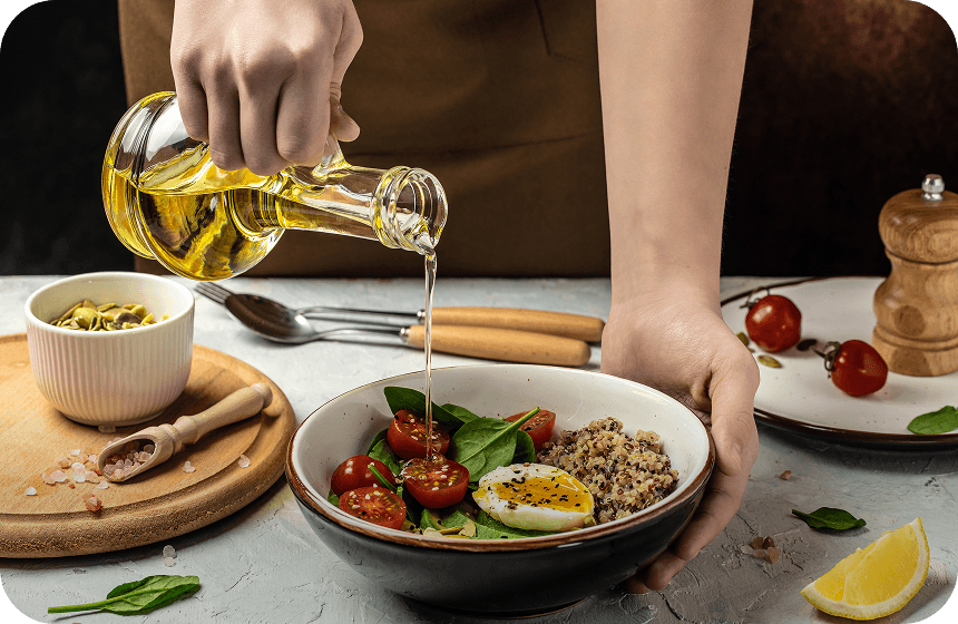 Pouring pure groundnut oil over a fresh salad